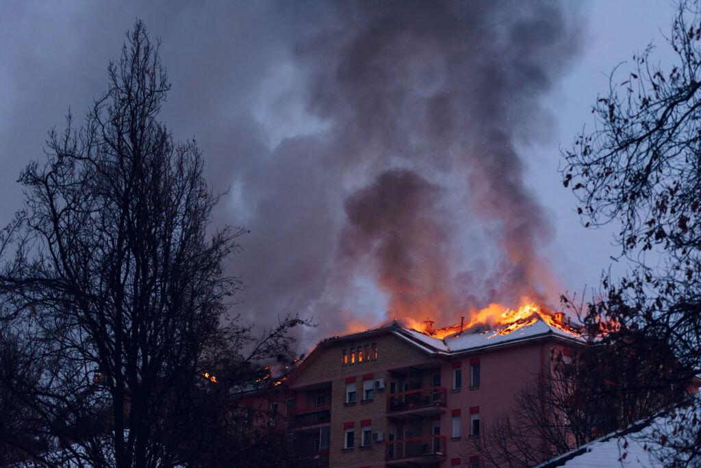 An apartment building on fire in the night.
