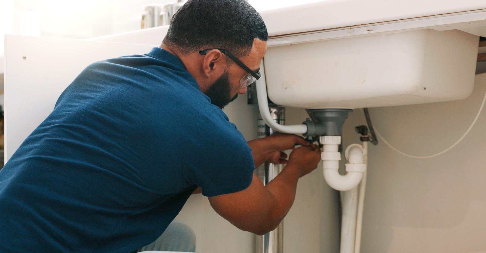 A professional plumber inspecting a clogged drain in a multifamily building.