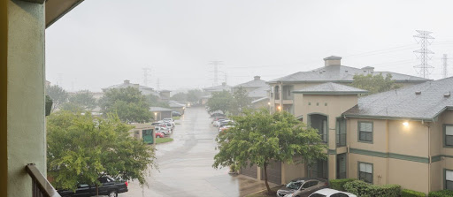 High winds and heavy rain battering a condominium building during a storm, emphasizing the importance of hurricane preparedness.