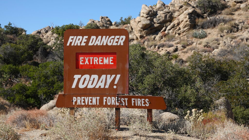 Fire damage warning sign in a forest during wildfire season, alerting visitors to the high risk of fire.