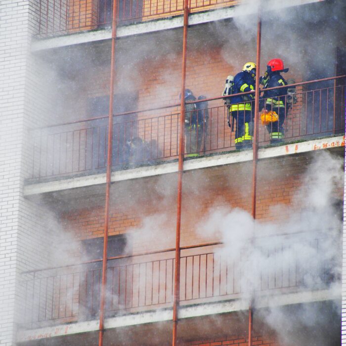 Firefighters working to extinguish a building fire, emphasizing the importance of restoring air quality after a fire.